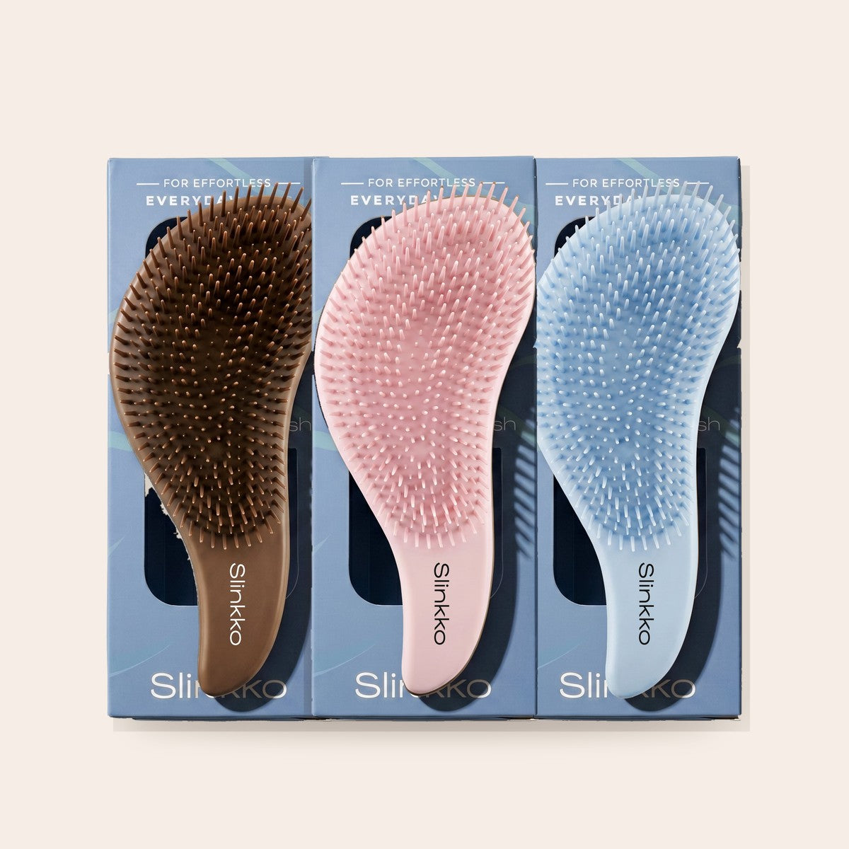 Slinkko Wave detangling brushes in Smoked Cocoa, Rose Clay and Mist Blue, in their packaging